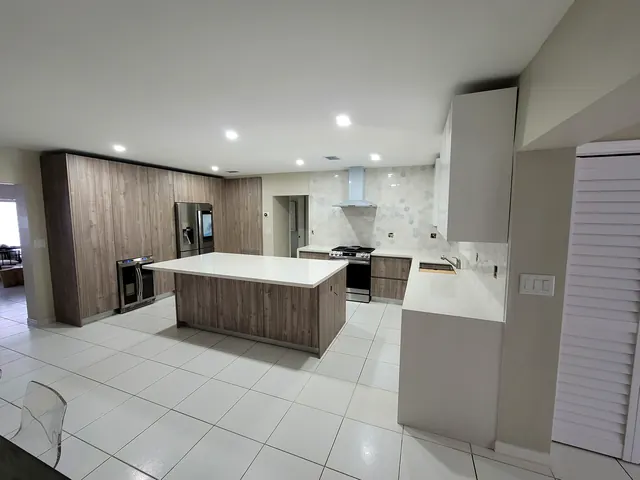 Custom kitchen with walnut cabinets and white quartz island, Miami
